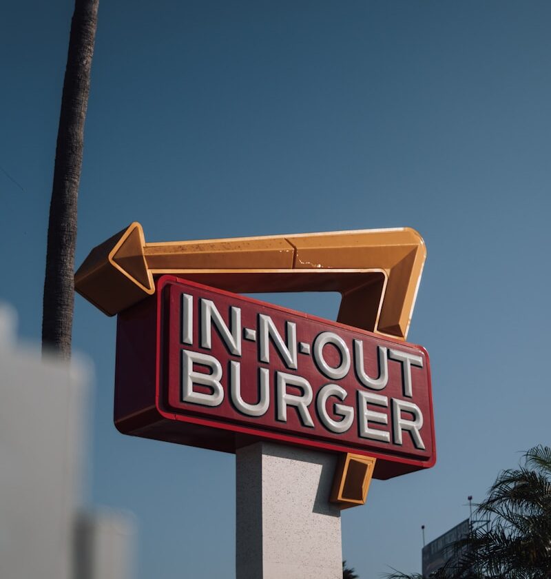 a red and white sign that says in - n - out burger