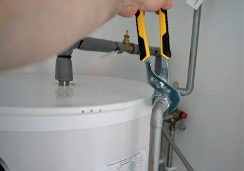 person holding yellow and gray hand tool