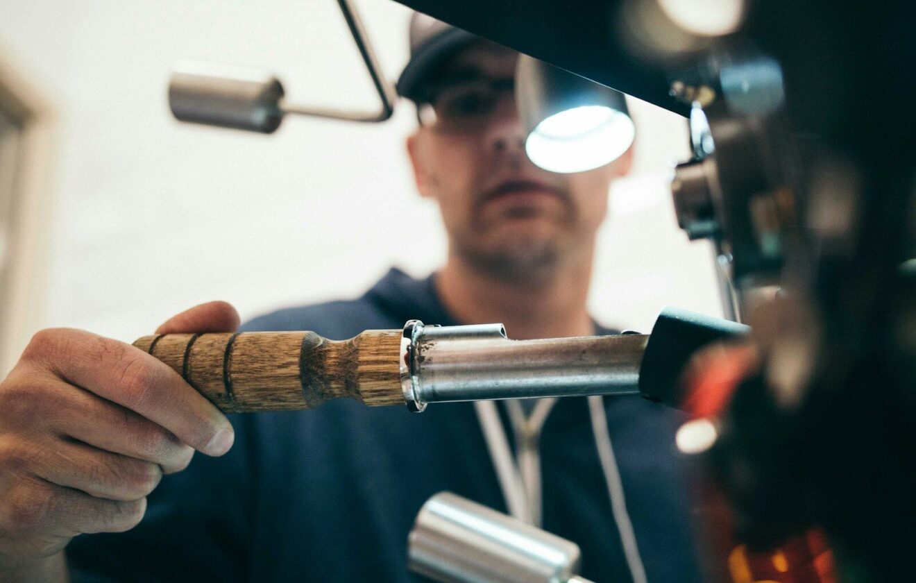 man wearing black pullover hoodie holding tool